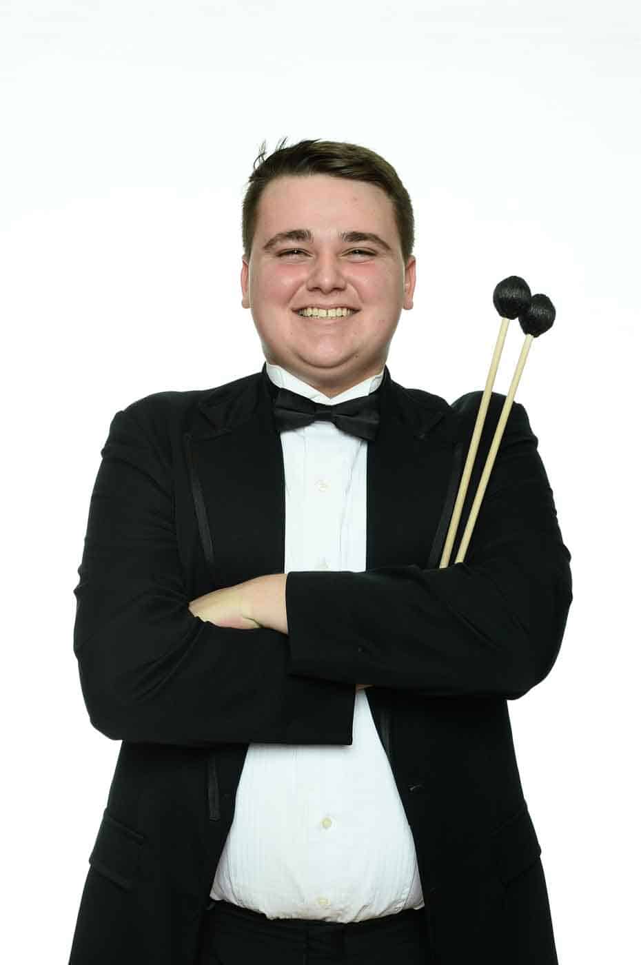 Young boy in suit with drum sticks