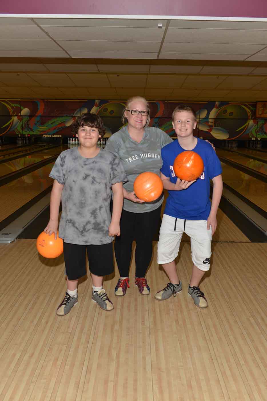 Mother and 2 sons posing at bowling alley
