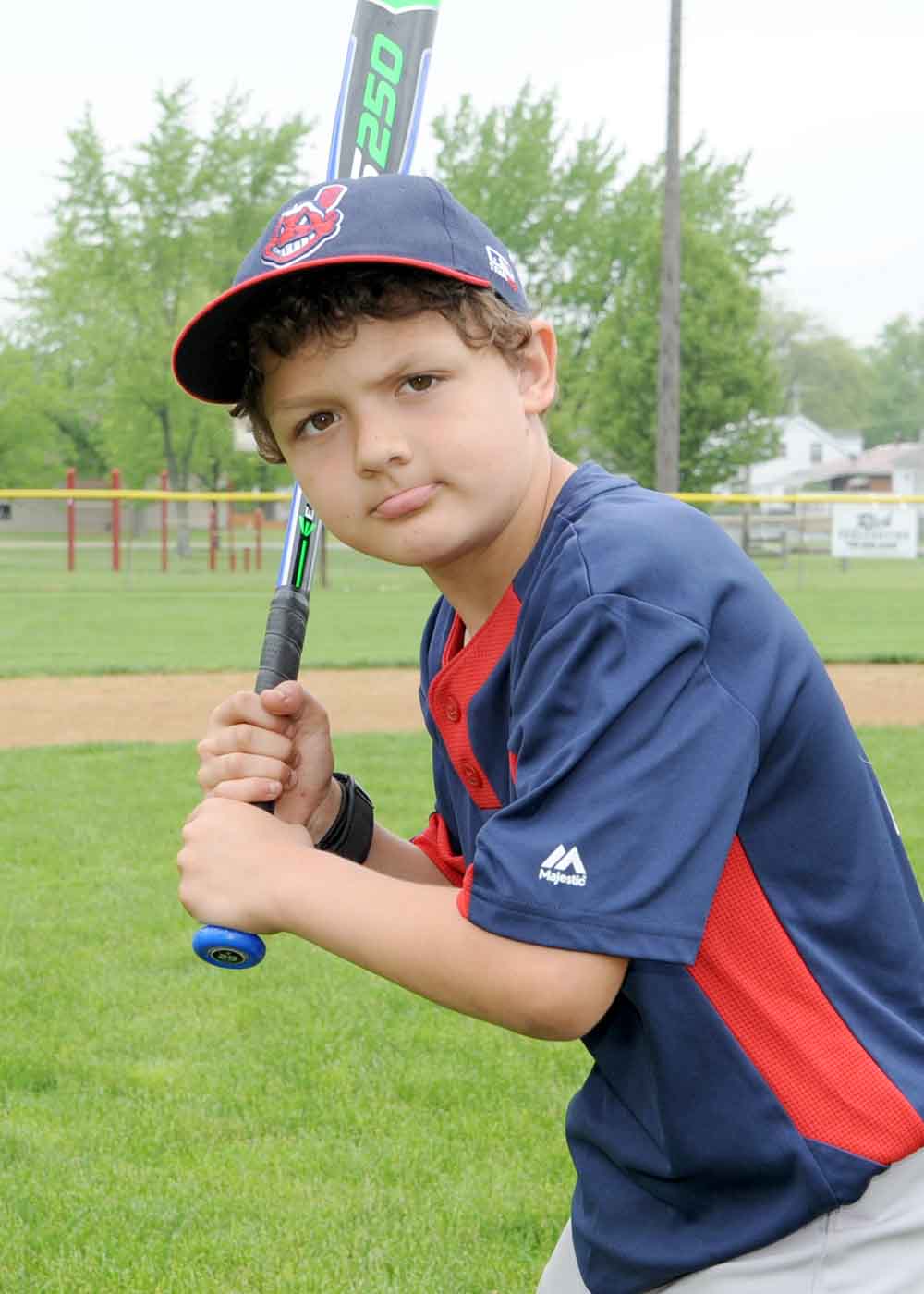 boy baseball player posing with bat