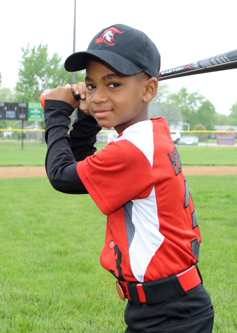 boy baseball player posing with bat