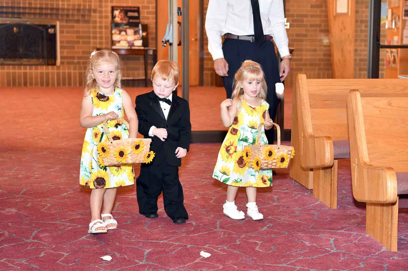 Flower girls and boy in suit entering church